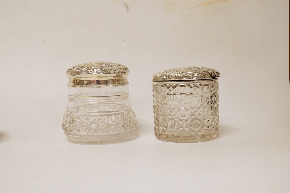 Six assorted silver lidded glass toilet jars including long rectangular, Birmingham, 1904, 22.9cm, together with a silver mounted hand mirror. Condition - poor